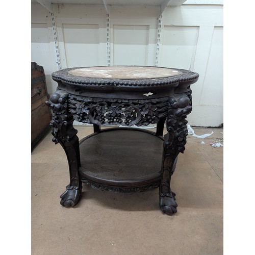 2048 - A Chinese hardwood two-tier Jardinière stand, with inset marble top, all over carved and pierced dec... 