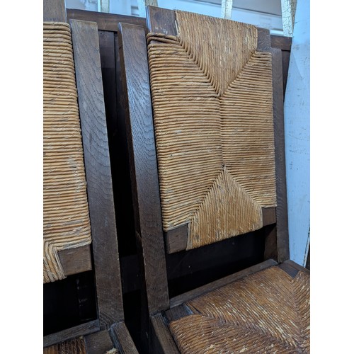 2071 - CHARLES DUDOUYT - A set of four mid-century brutalist oak dining chairs, each with rush drop-in seat... 