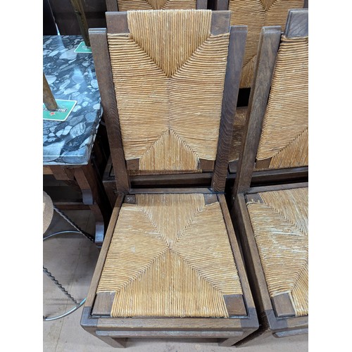 2071 - CHARLES DUDOUYT - A set of four mid-century brutalist oak dining chairs, each with rush drop-in seat... 