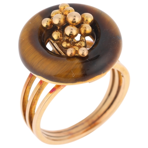 1297 - A 14ct gold modernist tigers eye ring, the polished tigers eye hoop with central organic form decora... 