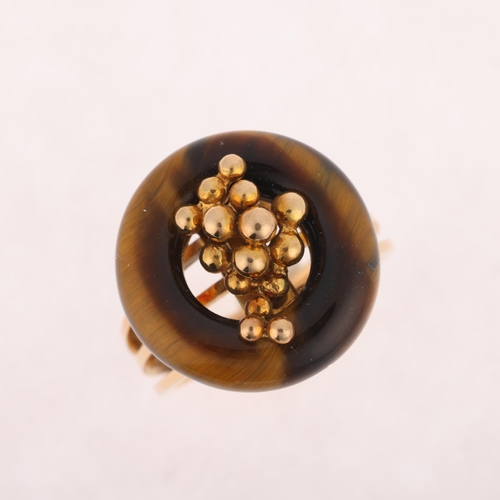 1297 - A 14ct gold modernist tigers eye ring, the polished tigers eye hoop with central organic form decora... 