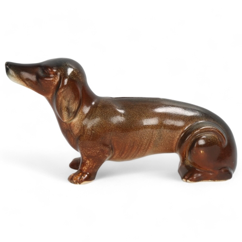 235 - A ceramic Austrian figurine of a Daschund as a money box, shaded brown glaze, base stamped Austria, ... 