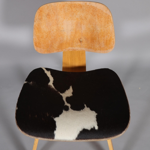 31 - An Eames LCW style chair with oak veneer bent ply and cowhide seat, no maker's mark, height 74cm