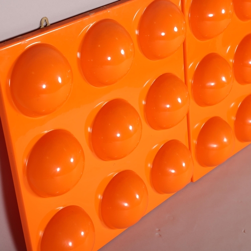 32 - A pair of orange plastic moulded wall-hanging panels, 58cm square