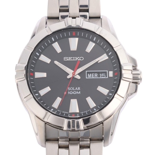 1042 - SEIKO - a stainless steel Solar 100M quartz day/date bracelet watch, ref. V158-0AH0, black dial with... 