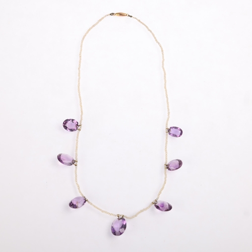 1100 - An Edwardian amethyst and seed pearl fringe necklace, the single row of seed pearls suspending 7 gra... 