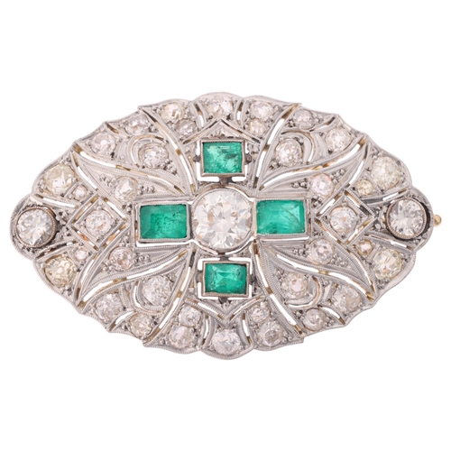 1104 - An Art Deco emerald and diamond plaque brooch, circa 1920, of shaped oval pierced form, centrally mi... 