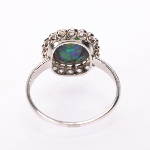 1122 - A platinum black opal and diamond cluster ring, centrally claw set with oval cabochon black opal sur... 