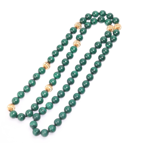 1144 - A long single strand 14ct gold malachite bead necklace, set with 10mm malachite beads having 7 x 14c... 