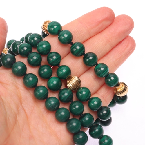 1144 - A long single strand 14ct gold malachite bead necklace, set with 10mm malachite beads having 7 x 14c... 