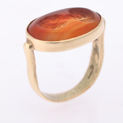 1148 - A hardstone intaglio ring, possibly Antique, the oval panel carved depicting male profile, in 9ct go... 