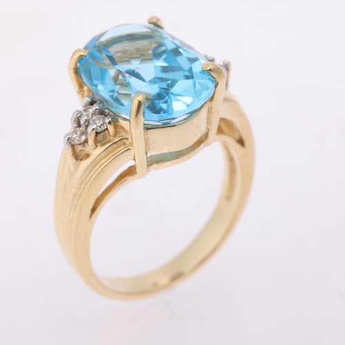 1155 - A 14ct gold blue topaz and diamond ring, claw set with oval mixed-cut topaz flanked by a trio of mod... 