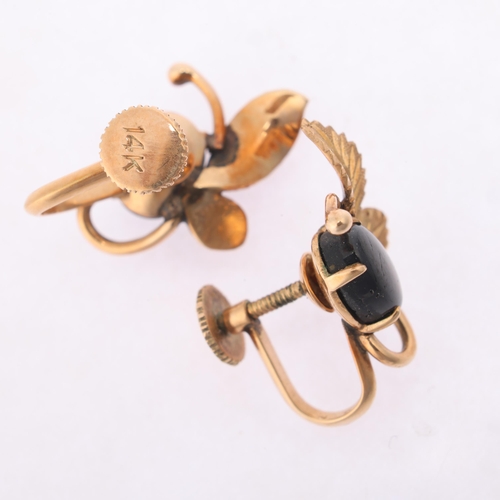 1157 - A pair of 14ct gold black star sapphire earrings, each claw set with oval cabochon sapphire within c... 