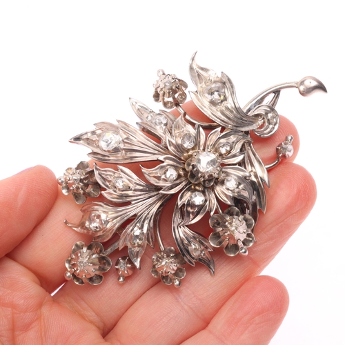 1160 - A large diamond floral spray brooch, realistically chased and set with rose-cut diamonds, the centre... 