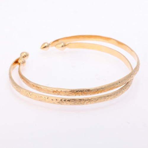 1166 - A pair of 10k gold cuff bangles, relief floral decoration with teardrop terminals, band width 4.3mm,... 