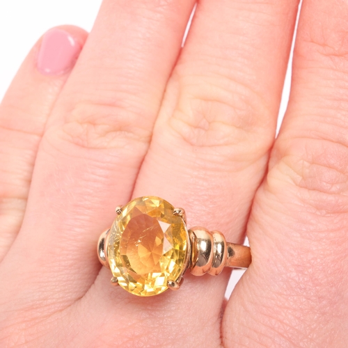 1204 - A 9ct gold single stone citrine dress ring, claw set with oval mixed-cut citrine, setting height 13.... 