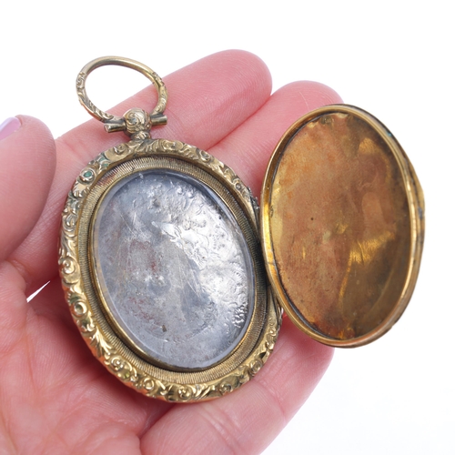 1219 - A large Antique Victorian gold plated locket pendant, oval form with allover engraved floral decorat... 