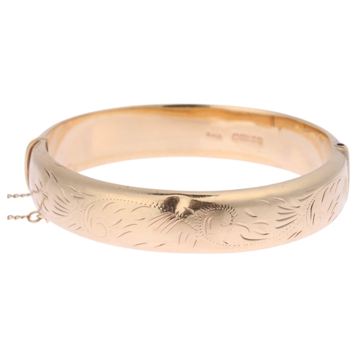 1252 - A 9ct gold hinged bangle, maker EJ Ltd, Birmingham 1984, foliate engraved decoration, band width 12.... 