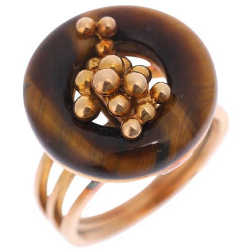 1297 - A 14ct gold modernist tigers eye ring, the polished tigers eye hoop with central organic form decora... 