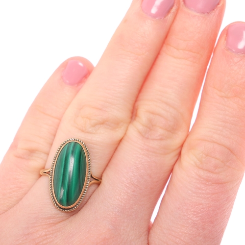 1312 - A 9ct gold malachite dress ring, rub over set with oval cabochon malachite within rope twist surroun... 