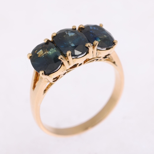 1316 - A 14ct gold three stone sapphire dress ring, claw set with oval mixed-cut sapphires, setting height ... 