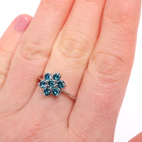 1323 - An 18ct white gold blue diamond flowerhead cluster ring, maker DK, Birmingham 2007, claw set with mo... 