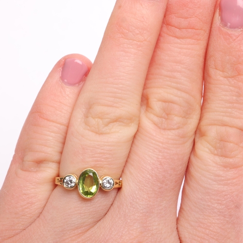 1360 - An 18ct gold three stone peridot and diamond ring, maker PP Ltd, Birmingham 1986, rub over set with ... 