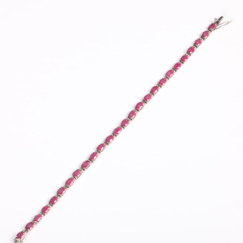 1434 - A sterling silver ruby tennis line bracelet, claw set with oval mixed-cut rubies, 20cm, 12.3g