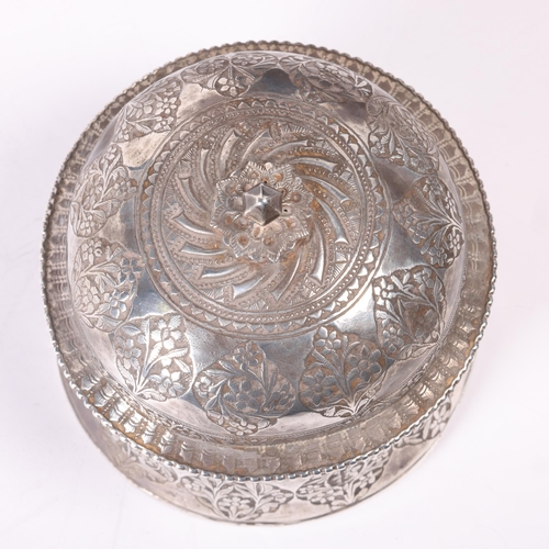 1580 - An Indian Mughal silver pandan/betel box and cover, circular form with relief embossed floral decora... 