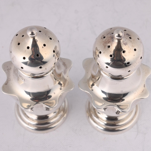 1643 - A pair of late Victorian silver pepperettes, James Deakin & Sons, Sheffield 1895, shaped baluster fo... 