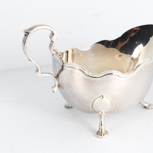 1739 - An Elizabeth II silver sauce boat, C J Vander Ltd, Sheffield 1959, raised scalloped rim on 3 feet, l... 