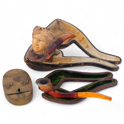 176 - A Meerschaum pipe with figural bowl (A/F), a small amber pipe with hoof design bowl, cased, and a Du... 