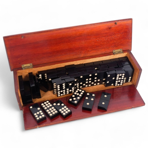 192 - A set of 50 dominos, housed in a fall-front mahogany box