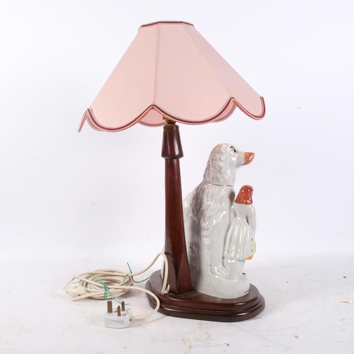 357 - A table lamp with pink shade, supported by a Staffordshire Spaniel and figure, H56cm