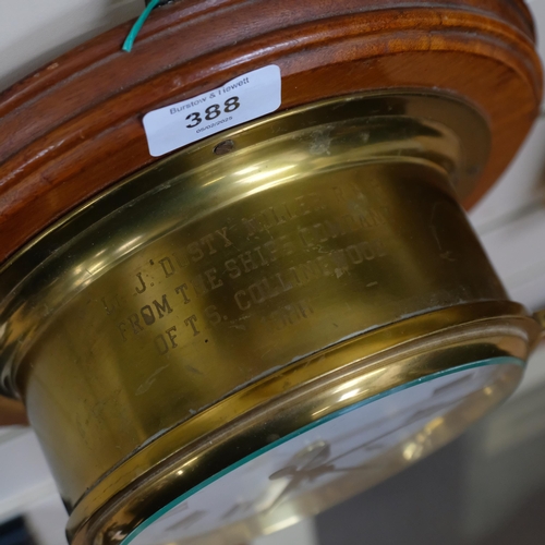 388 - A brass-cased ship's bulkhead clock by Sestrel, mounted on a teak circular panel, the brass case eng... 