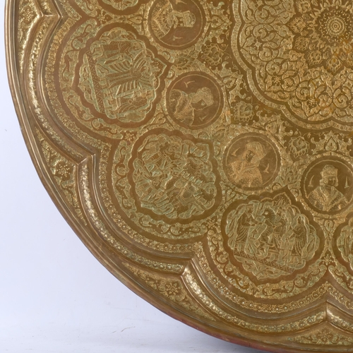 403 - A large Persian brass charger with shaped border, allover engraved and repousse decoration, diameter... 