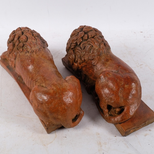 449 - An opposing pair of terracotta pottery recumbent lions, 30cm