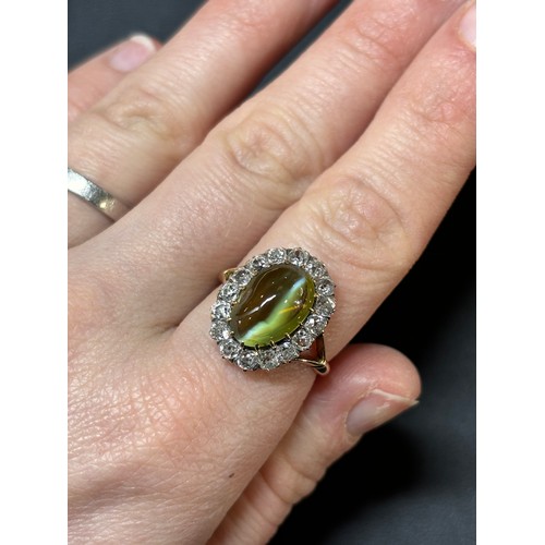 1103 - An Antique 18ct gold cat's eye chrysoberyl and diamond cluster ring, late 19th century, set with a 4... 