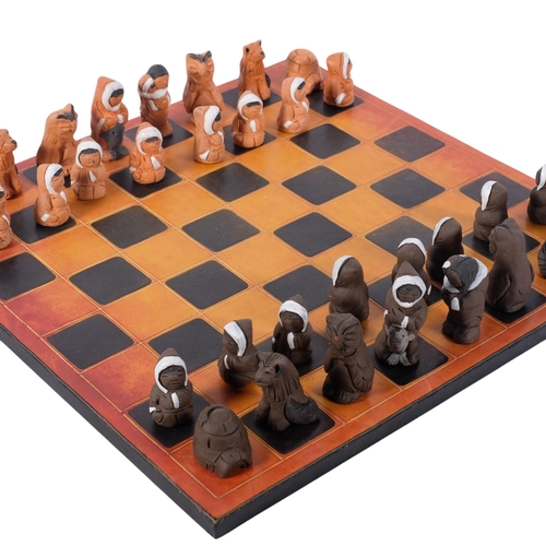 829 - An Inuit figure pottery chess set, signed Eija Seras, with leather-covered games board, 39cm across