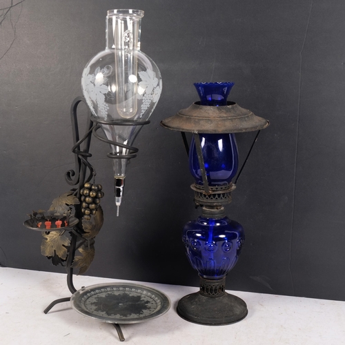 833 - A Continental wine jug, with candle holder on wrought-metal stand, H52cm, and a blue glass oil lamp