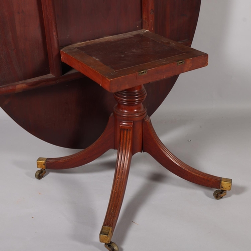 502 - A Regency oval mahogany tilt-top dining table, on quadruple base, 152cm x 119cm (5' x 3'11