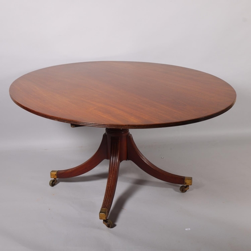 502 - A Regency oval mahogany tilt-top dining table, on quadruple base, 152cm x 119cm (5' x 3'11