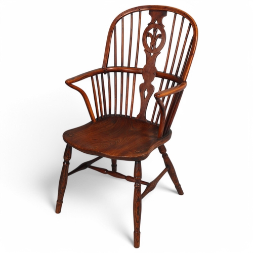 499 - An early 19th century yew wood bow arm Windsor chair, with Prince of Wales Feather design splat and ... 