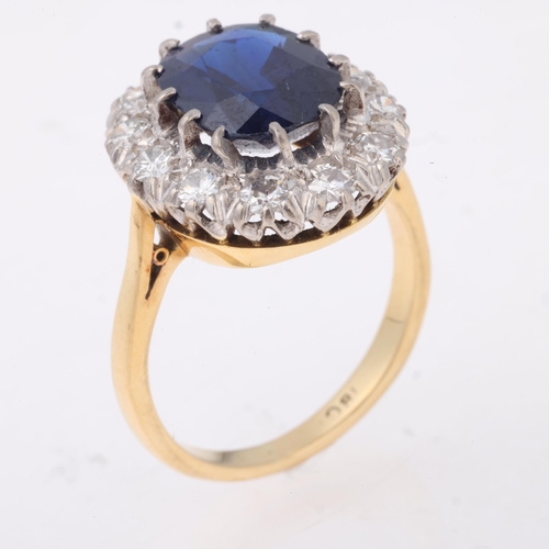 1136 - An 18ct gold sapphire and diamond cluster ring, claw set with 3.8ct oval mixed-cut sapphire surround... 