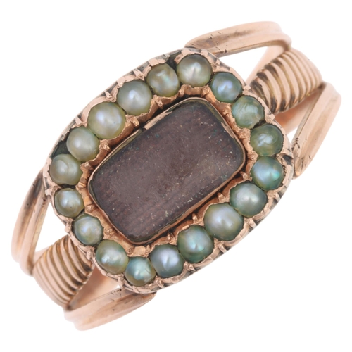 1173 - An Antique Georgian hairwork split pearl mourning ring, the oval panel with central convex glazed co... 