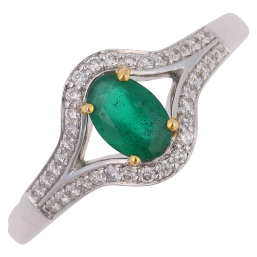 1192 - An 18ct white gold emerald and diamond ring, maker LA, Birmingham 2007, claw set with oval mixed-cut... 