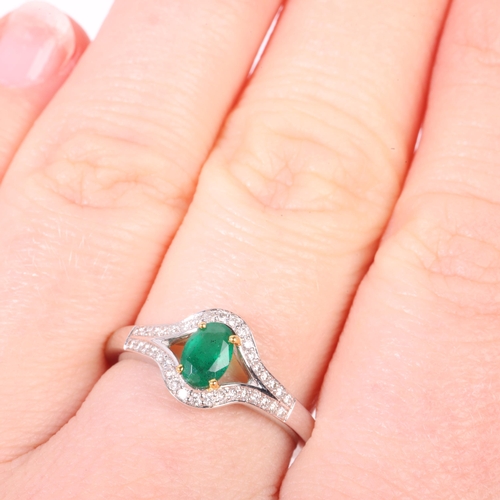 1192 - An 18ct white gold emerald and diamond ring, maker LA, Birmingham 2007, claw set with oval mixed-cut... 