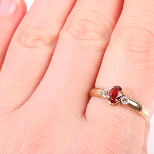 1271 - A 9ct gold three stone garnet and diamond ring, claw set with oval mixed-cut garnet and single-cut d... 