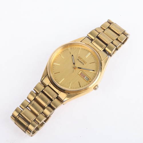 1038 - SEIKO - a gold plated stainless steel quartz calendar bracelet watch, ref. 7N43-7A50, champagne dial... 