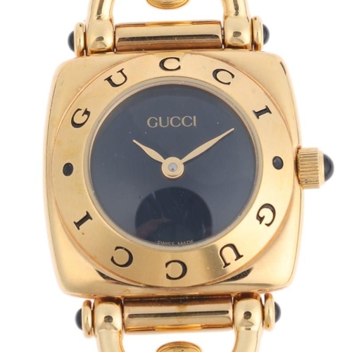 1065 - GUCCI - a lady's gold plated 6300L quartz wristwatch, blue dial with gilt leaf hands and Gucci bezel... 